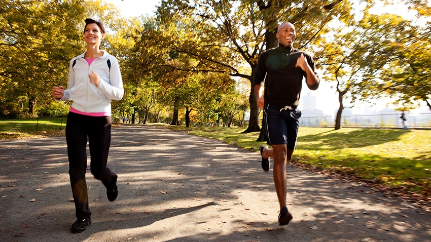 Two adults jogging down lane