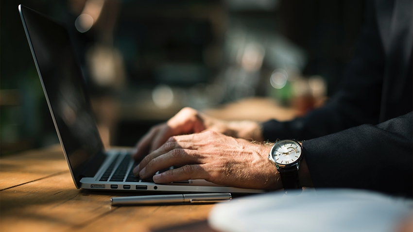 Male hands typing on a laptop